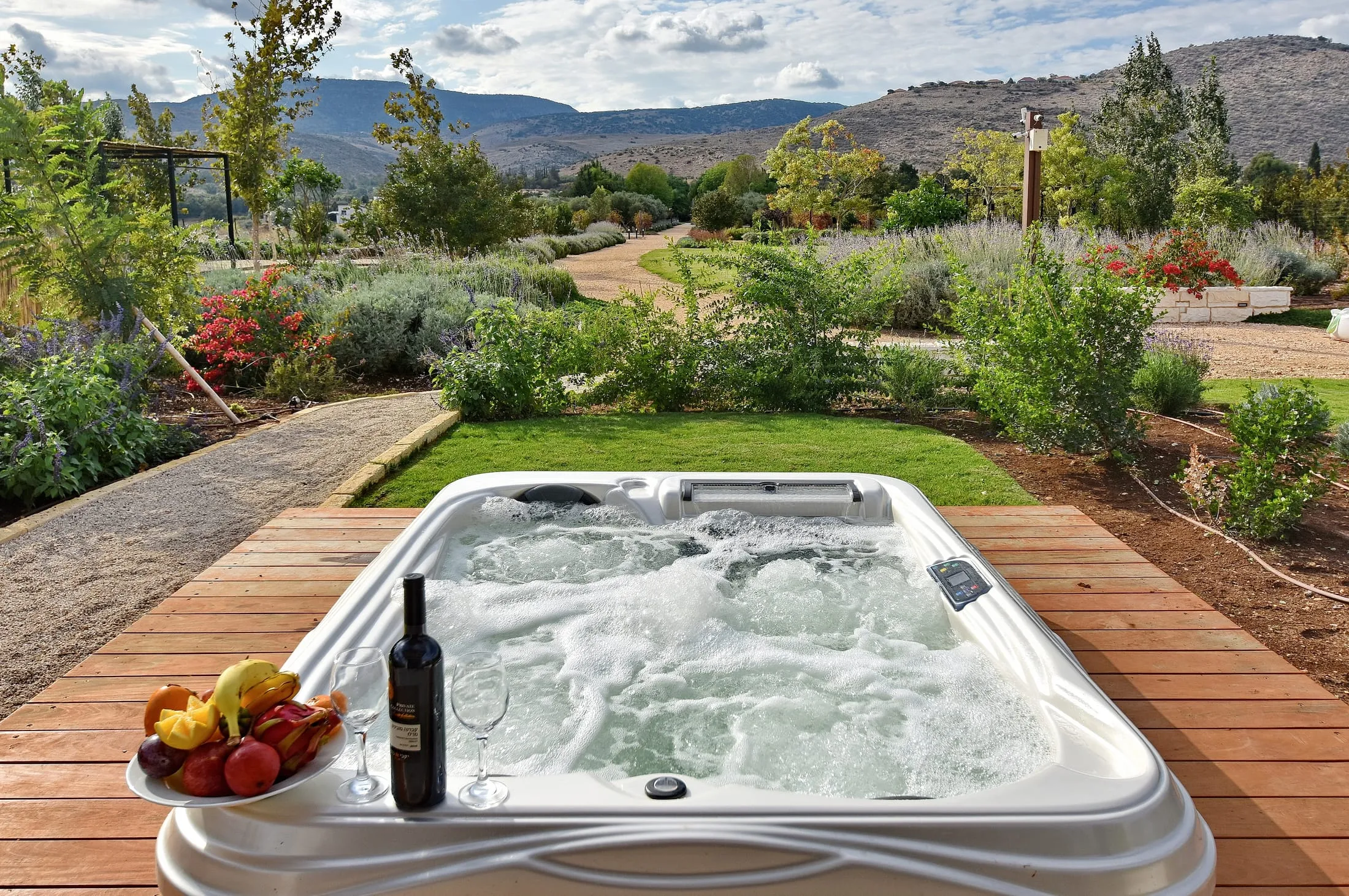 Suite deck jacuzzi with wine and fruit overlooking flowering gardens and Galilee mountains